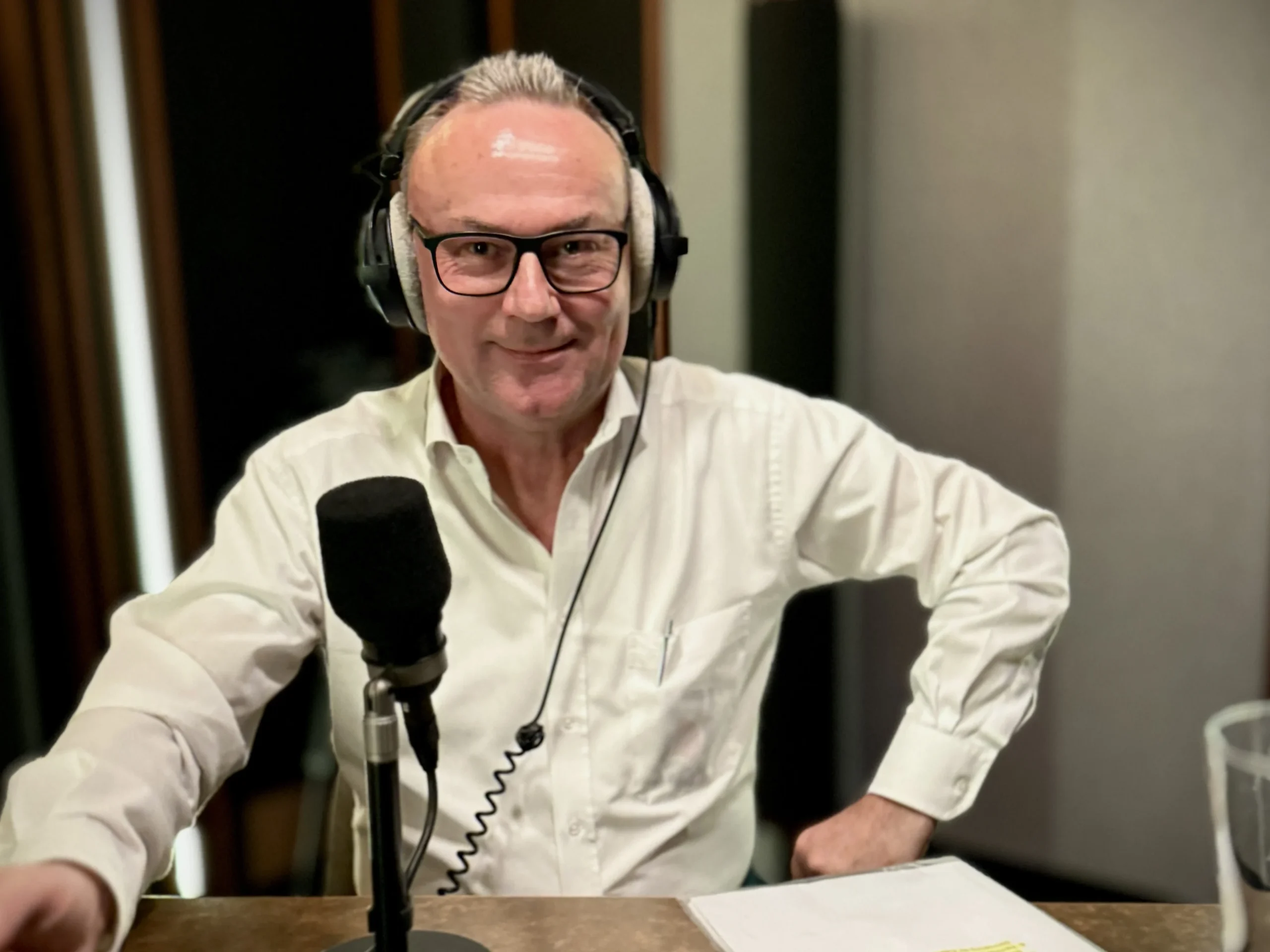 Daniel Dietrich mit Kopfhörern und Mikrofon bei Home of Podcast.